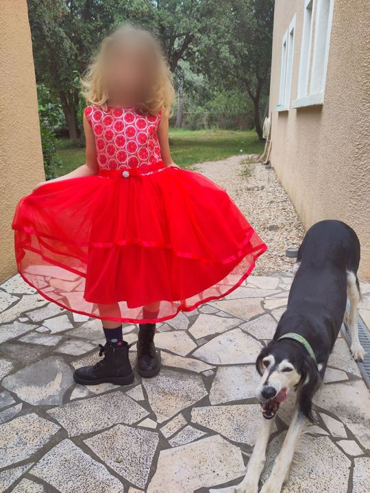 A girl in a red dress standing with Sagi
